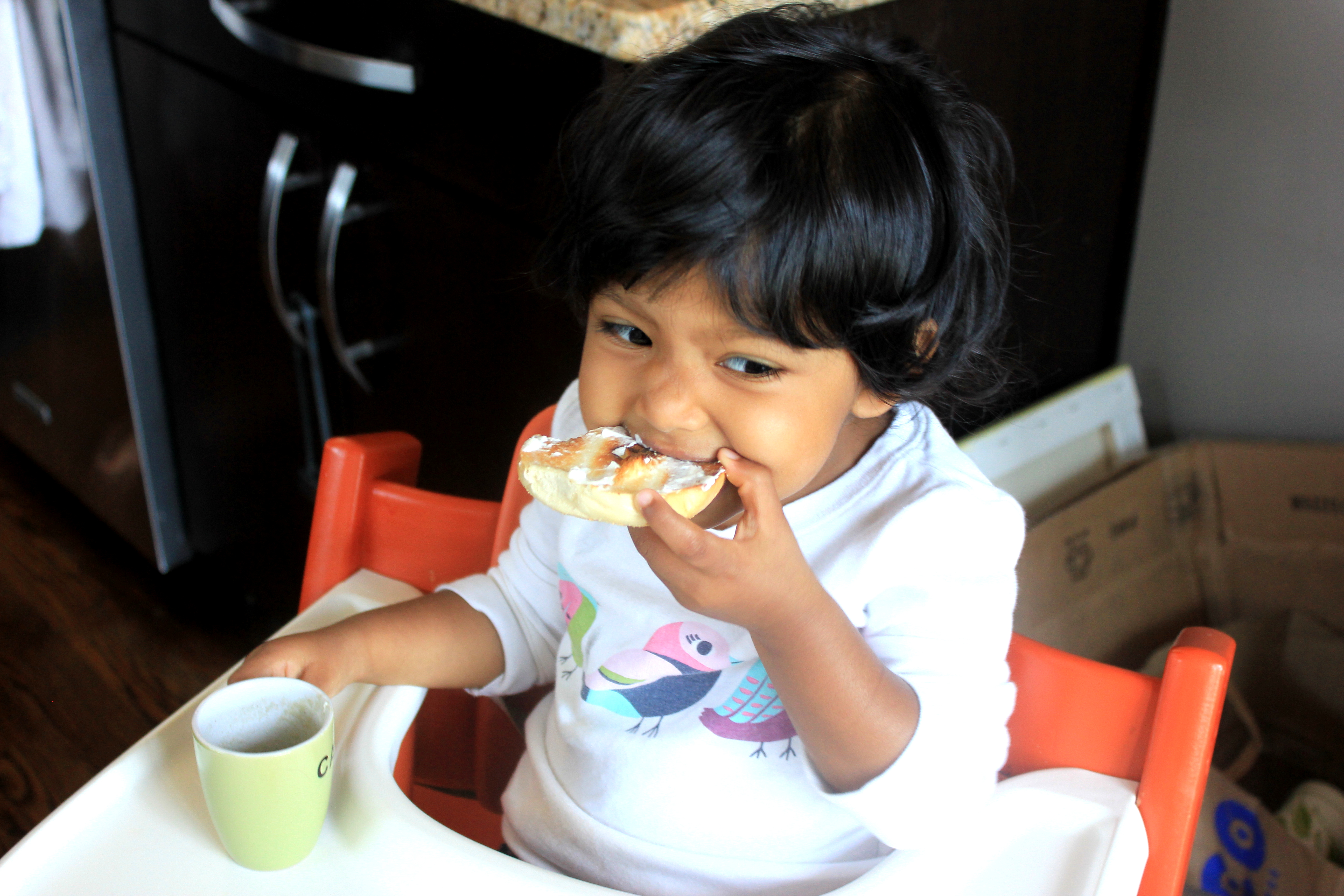Asha eating bagel and "coffee"